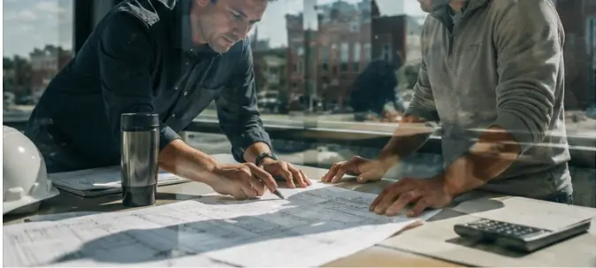 cm-intro-two-men-blueprints-window